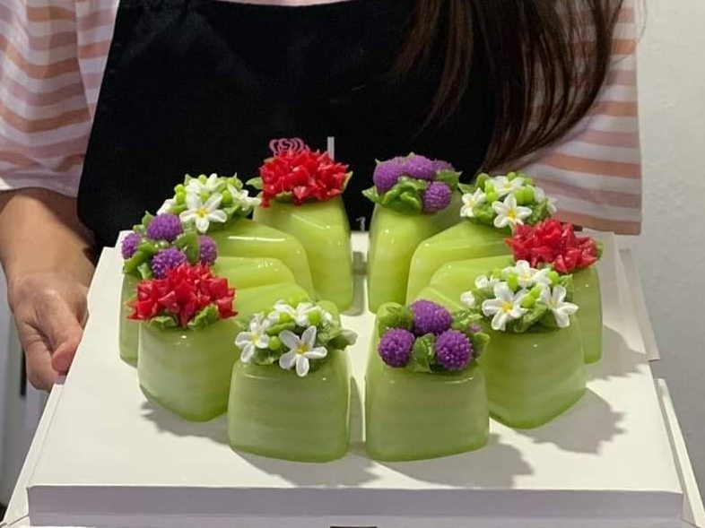 ขนมชั้น แบ่งชิ้น 3 เหลี่ยม แต่งหน้าอาลัวดอกไม้ไทย